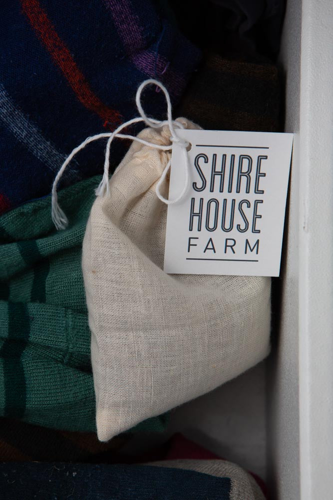 A cotton pouch of lavender buds, with a swing tag attached, in a sock drawer