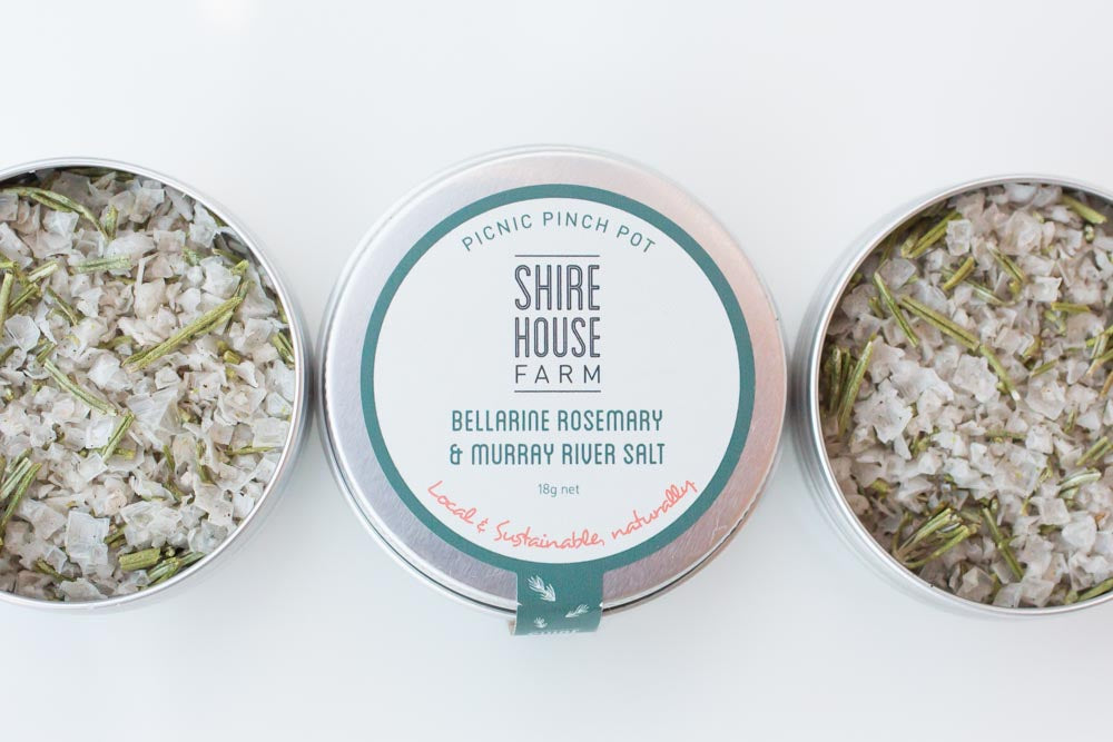 Three tins of salt, two either side without their lids, on a white background