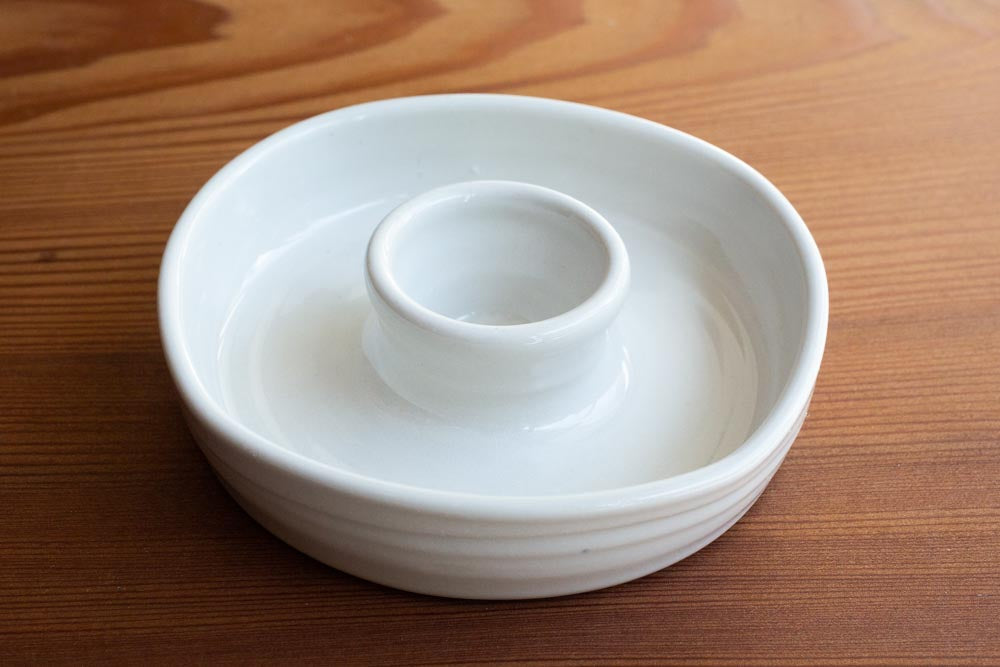 An olive dish on a wood surface