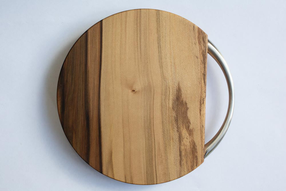 A cheese board with a silver handle, on a white background