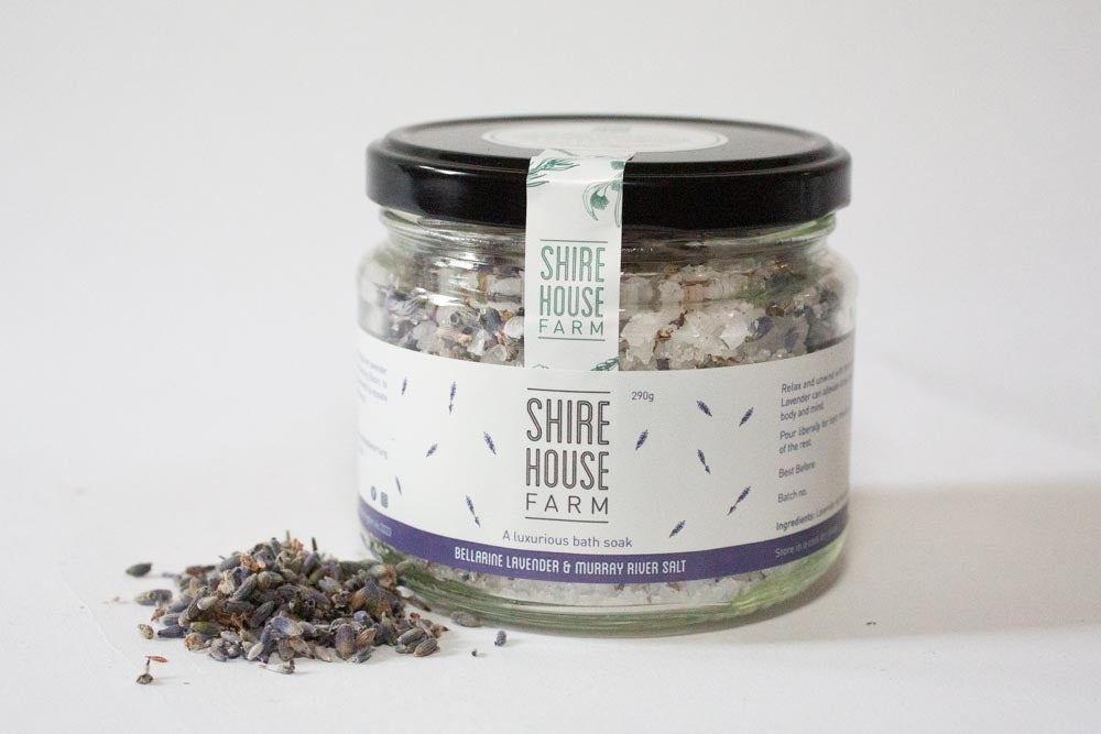 A jar of bath salt, with lavender buds on the side, on a white background