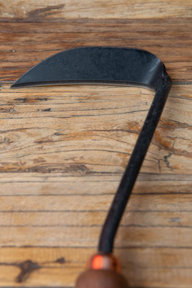 the top of a weeding hoe, on a wood surface