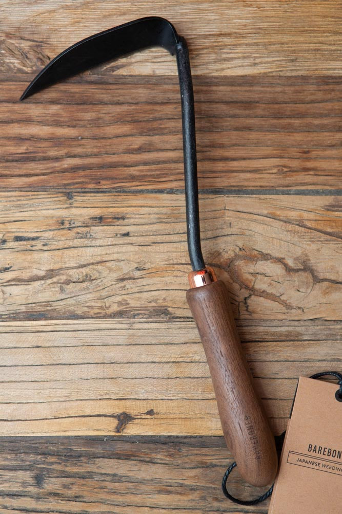 weeding hoe with wood handle, on a wood surface